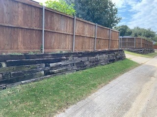Before Replaced cross tie retaining wall with Milsap stone and reinstalled fence on top of new wall in Coppell-min