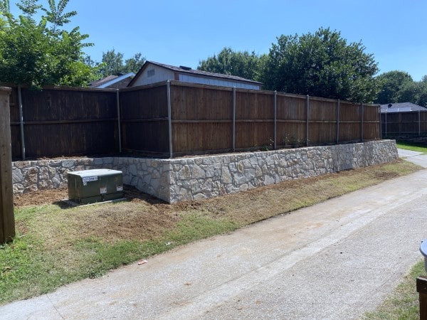 Replaced cross tie retaining wall with Milsap stone and reinstalled fence on top of new wall in Coppell Texas-min