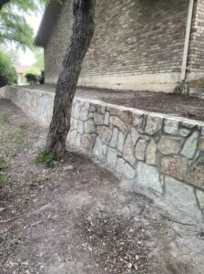New Milsap stone retaining wall replacing failed cinder block wall beside brick home in Plano TX