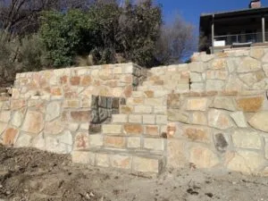 Multi-tier Milsap stone retaining wall with integrated stone steps replacing old crosstie system, Fort Worth TX