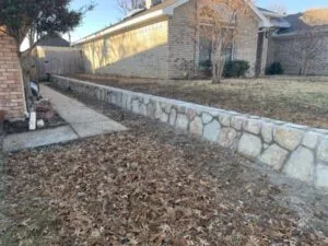 Completed Milsap stone retaining wall replacing a failing crosstie wall along a residential sidewalk in Euless TX