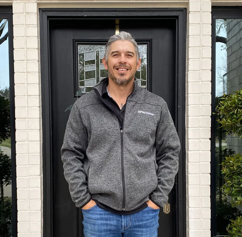 Nathan Rodriguez, owner-operator of DFW Retaining Walls and Pool Demo, standing at a residential front door in Fort Worth TX