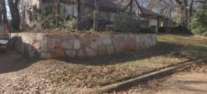 Milsap or Granbury stone retaining wall replacing old crosstie wall along residential front yard in Carrollton TX