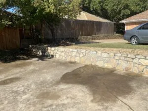 Completed Milsap stone retaining wall replacing failed crosstie wall along residential driveway in Grand Prairie TX