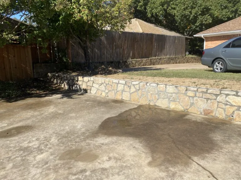 Completed Milsap stone retaining wall replacing failed crosstie wall along residential driveway in Grand Prairie TX