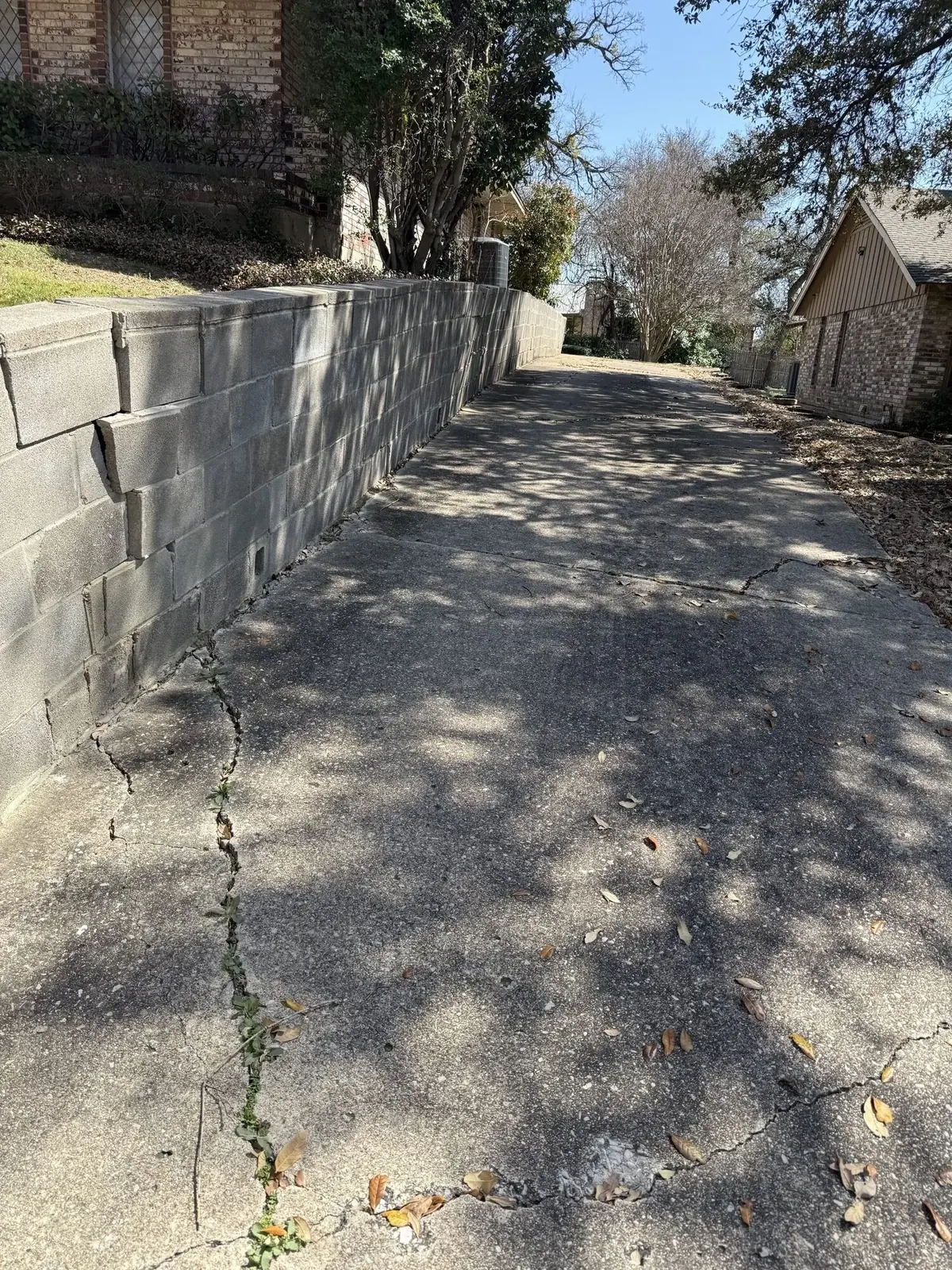 Natural stone retaining wall replacing an older timber wall in Irving / Las Colinas, TX