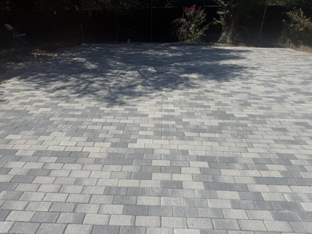 Smooth gray paver surface filling a backyard after pool removal and demolition in Plano TX, graded and ready for use