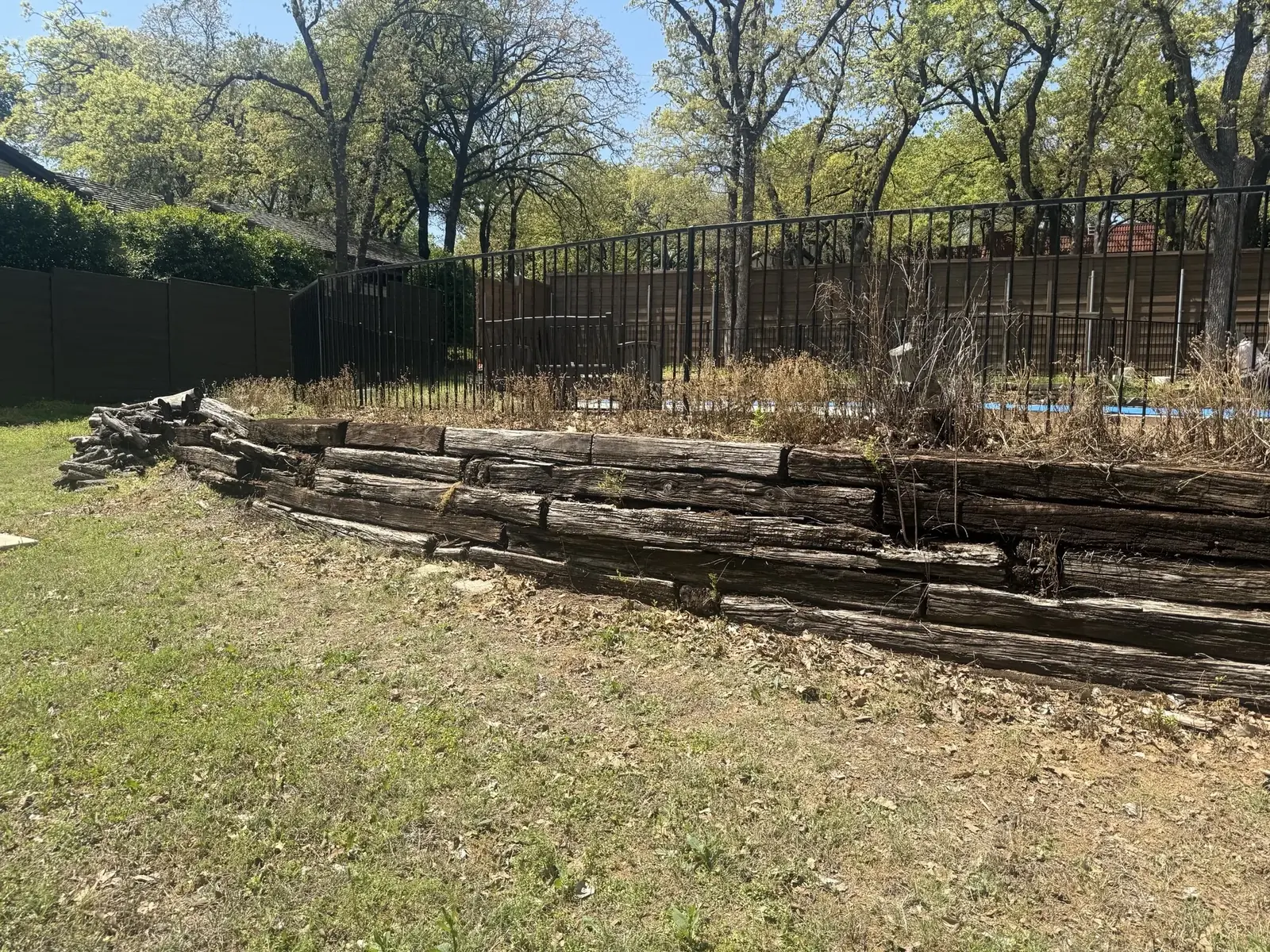 Natural stone retaining wall replacing an older timber wall in Bartonville, TX
