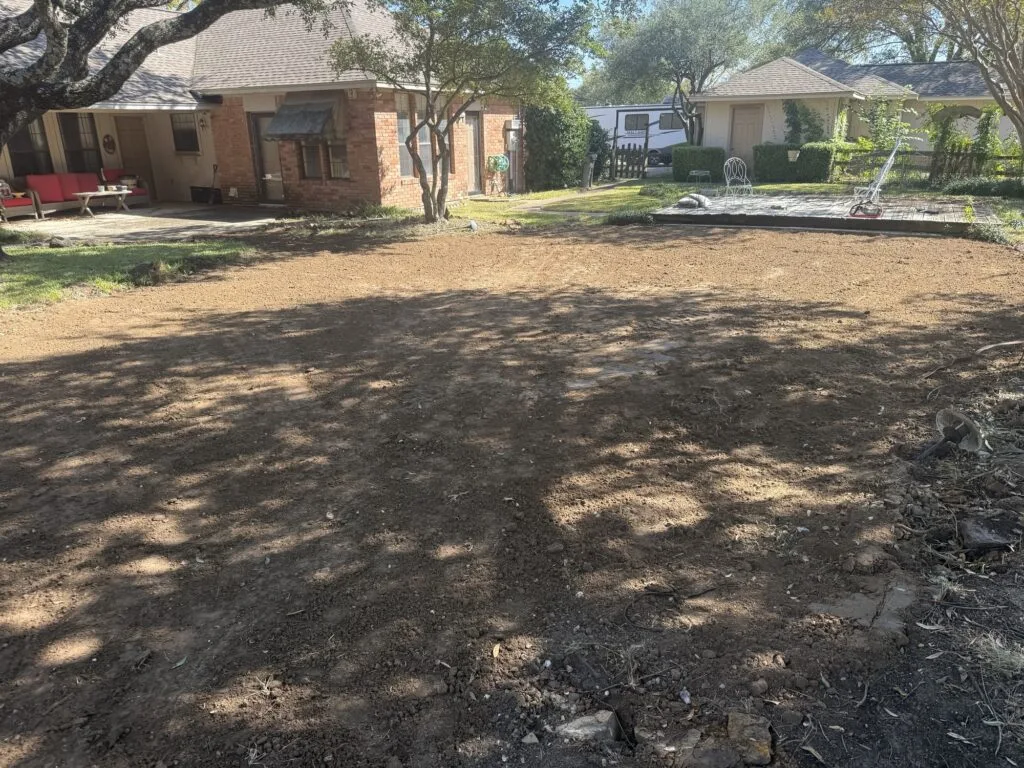 Backyard after complete pool removal, fully backfilled and graded flat beside brick home in Plano TX