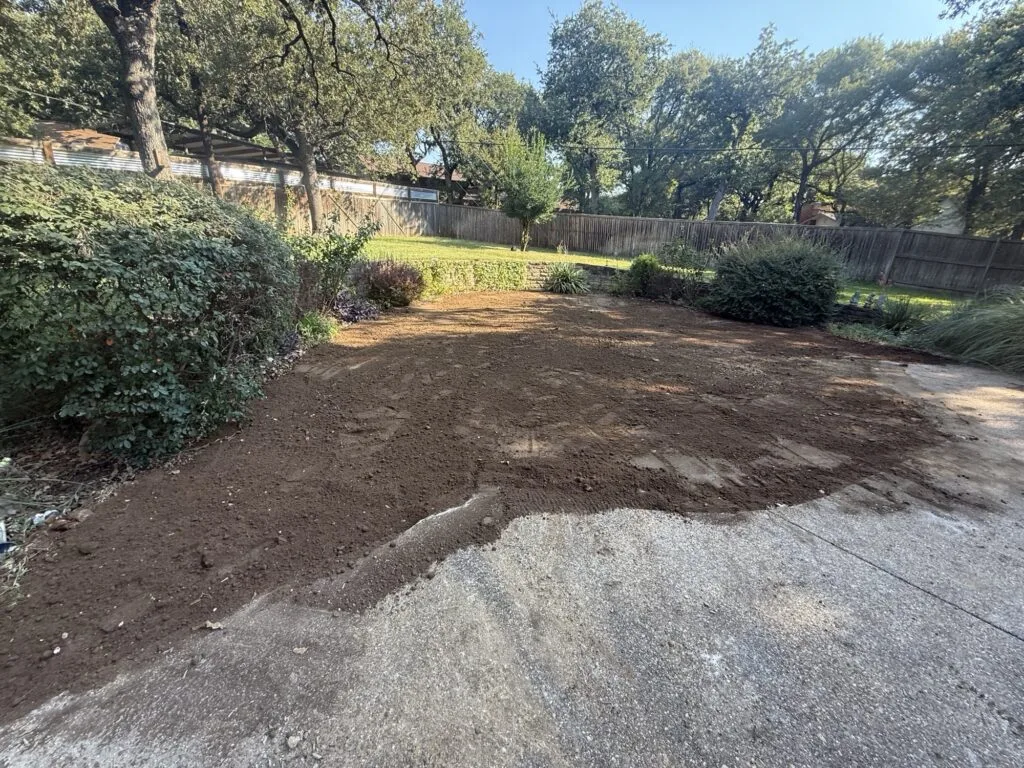Backyard after pool removal in Plano TX — freshly backfilled, compacted, and graded soil ready for new use