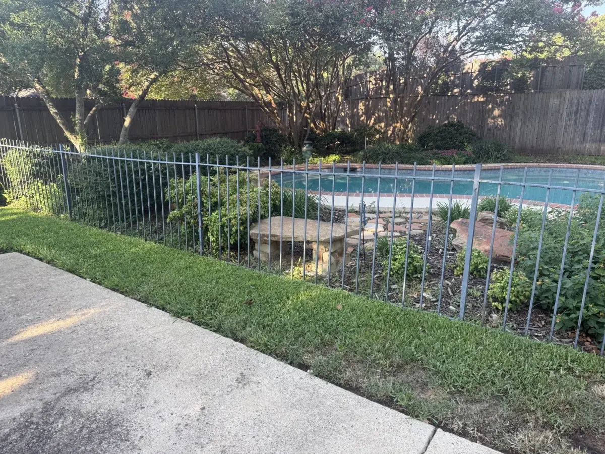 Fenced in-ground pool surrounded by overgrowth in Arlington, TX before removal by DFW Retaining Walls and Pool Demo